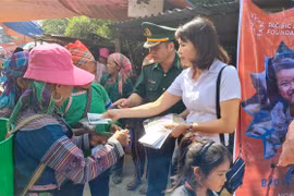 Phát tờ rơi tuyên truyền về phòng, chống mua bán người cho phụ nữ dân tộc thiểu số tại chợ trung tâm xã Tả Gia Khâu, huyện Mường Khương, tỉnh Lào Cai. (Ảnh: Hương Thu/TTXVN)