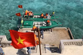 Cờ Tổ quốc tung bay phấp phới khi hai xuồng của tàu Trường Sa 571 cập mạn trên đảo Cô Lin. (Ảnh: Sỹ Tuyên/TTXVN) 