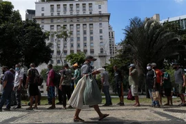 Người vô gia cư xếp hàng chờ nhận bữa ăn miễn phí tại Sao Paulo, Brazil. (Ảnh: AFP/TTXVN) 