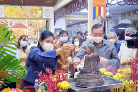 Bà Wiraka Mudhitaporn, Tổng lãnh sự Thái Lan tại Thành phố Hồ Chí Minh (trái) thực hiện nghi thức tắm Phật tại lễ hội. (Ảnh: Xuân Khu/TTXVN) 