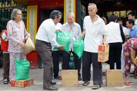 Hội quán Ôn Lăng (của cộng đồng người Hoa) cùng Hội Chữ Thập đỏ Quận 5 tặng quà định kỳ giúp hộ nghèo, người già neo đơn, đóng góp một phần tích cực trong chương trình xóa đói giảm nghèo của địa phương. (Ảnh: Thanh Vũ/TTXVN) 