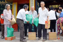 Hội quán Ôn Lăng (của cộng đồng người Hoa) cùng Hội Chữ Thập đỏ Quận 5 tặng quà định kỳ giúp hộ nghèo, người già neo đơn, đóng góp một phần tích cực trong chương trình xóa đói giảm nghèo của địa phương. (Ảnh: Thanh Vũ/TTXVN) 