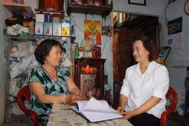 Chị Hồng, chuyên trách giảm nghèo địa phương (phải) thăm hỏi gia đình chị Triệu Lệ Anh, ngụ tại phường 15, Quận 5 (trái) tự nỗ lực vươn lên, thoát khỏi cận nghèo theo tiêu chí thành phố từ đầu năm 2020. (Ảnh: Thanh Vũ/TTXVN) 