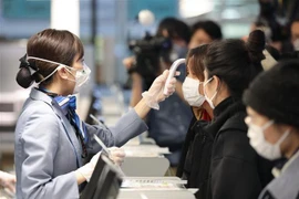 Nhân viên hàng không kiểm tra thân nhiệt các hành khách trước khi họ về Vũ Hán (Trung Quốc) tại sân bay quốc tế thủ đô Tokyo, Nhật Bản ngày 31/1/2020. (Nguồn: THX/TTXVN) 