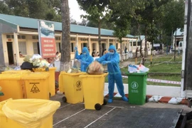 Các nhân viên Công ty Cổ phần Nước-Môi trường Bình Dương (Biwase) thu gom rác thải y tế ở các khu điều trị bệnh nhân COVID-19. (Ảnh: Huyền Trang/TTXVN) 