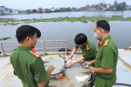 Công an đang niêm phong khoang chừa xăng dầu tại điểm phá án trên sông Hậu. (Nguồn: tuoitre.vn) 