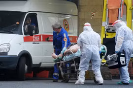 Nhân viên y tế chuyển bệnh nhân nhiễm COVID-19 tới bệnh viện ở Saint Petersburg, Nga. (Nguồn: AFP/TTXVN) 