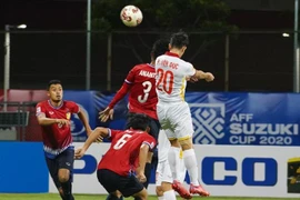 Tiền vệ Phan Văn Đức tranh bóng trên không với các cầu thủ Lào. (Ảnh: TTXVN phát) 