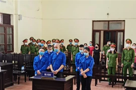 Bị cáo Nguyễn Văn Dũng (tức Dũng trọc, đứng trước) cùng các bị cáo Lê Xuân Hùng, Nguyễn Văn Thanh, Khà Văn Linh và Trần Thị Ngọc Quỳnh tại phiên tòa xét xử. (Ảnh: Vũ Hà/ TTXVN) 
