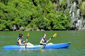 Du khách trải nghiệm chèo thuyền kayak, thuyền tay trên Vịnh Hạ Long. (Ảnh: Thanh Vân/TTXVN)