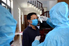 Người dân trong khu dân cư Đa Phước 6 (phường Hòa Khánh Bắc, quận Liên Chiểu, thành phố Đà Nẵng) chấp hành các quy định cách ly tại nhà và kiểm tra thân nhiệt hằng ngày. (Ảnh: Quốc Dũng/TTXVN) 