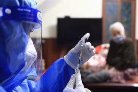 Y tá Hoàng Thùy Linh (trạm y tế phường Hàng Bài, Hoàn Kiếm) chuẩn bị tiêm vaccine Pfizer cho người cao tuổi, có bệnh lý nền ngay tại nhà. (Ảnh: Hoàng Hiếu/TTXVN) 
