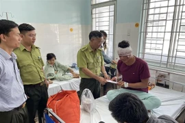 Lãnh đạo Chi cục Kiểm lâm Đồng Nai thăm hỏi, động viên kiểm lâm viên Chìu Văn Hai (kiểm lâm của Vườn quốc gia Cát Tiên) đang điều trị tại bệnh viện. (Ảnh: TTXVN phát)