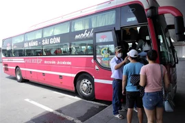 Hành khách được đo thân nhiệt trước khi lên xe rời Đà Nẵng. (Ảnh: Trần Lê Lâm/TTXVN) 