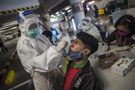 Nhân viên y tế lấy mẫu xét nghiệm COVID-19 cho người dân tại Surabaya, Indonesia ngày 17/6/2021. (Ảnh: AFP/TTXVN) 