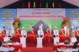 Trưởng Ban Tuyên giáo Trung ương Nguyễn Trọng Nghĩa và các đại biểu nhấn nút khởi công tuyến đường ven biển đoạn Cát Tiến-Diêm Vân. (Ảnh: Kha Phạm/TTXVN) 