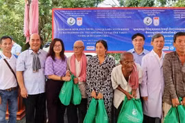 Tổng Lãnh sự Việt Nam tại Sihanoukville Lại Xuân Chiến (bên trái) và đại diện đoàn Việt Nam tặng quà từ thiện cho người dân tại phường Roka Knong, thành phố Daun Keo, tỉnh Takeo. (Ảnh: Quang Anh/TTXVN)