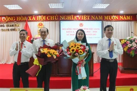 Bà Võ Thị Mỹ Trang và ông Trần Thanh Lâm nhận hoa chúc mừng từ lãnh đạo tỉnh. (Ảnh: Hồng Thái/TTXVN) 