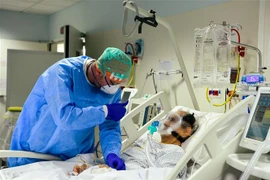 Nhân viên y tế động viên một bệnh nhân mắc COVID-19 tại một bệnh viện ở Bergamo, Italy ngày 3/4/2020. (Nguồn: AFP/TTXVN) 