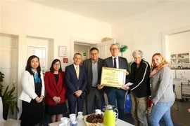 Đại sứ Vũ Quang Minh (thứ ba từ trái) trao 3.000 euro cho bà Maria Richter Giam đốc trung tâm bảo trợ và (thứ hai từ phải) và ông Chủ tịch quận Lichtenberg Martin Grunst (thứ tư từ trái). (Ảnh: Phương Hoa/TTXVN)
