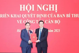 Ông Mai Văn Chính, Ủy viên Trung ương Đảng, Phó Trưởng Ban Tổ chức Trung ương, trao quyết định bổ nhiệm chức vụ Phó Tổng Biên tập phụ trách Tạp chí Cộng sản cho ông Phạm Minh Tuấn. (Ảnh: Phương Hoa/TTXVN)