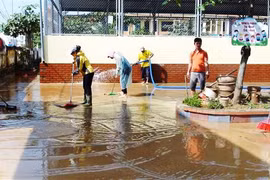 Cán bộ, giáo viên cùng các lực lượng tình nguyện viên đã được huy động để khẩn trương dọn dẹp vệ sinh, khắc phục hậu quả mưa lũ tại Trường Tiểu học và Trung học cơ sở Phú Hải (thành phố Đồng Hới). (Ảnh: Võ Dung/TTXVN) 