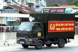 Lực lượng chức năng đẩy mạnh thông tin tuyên truyền ở các địa điểm đông dân cư. (Ảnh: Trung Hiếu/TTXVN) 