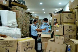 Cơ quan chức năng kiểm tra hàng hóa vi phạm. (Ảnh: TTXVN phát) 