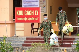 Lực lượng chức năng thu gom rác thải sinh hoạt tại khu vực cách ly y tế. (Ảnh: Trung Kiên/TTXVN) 