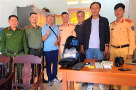 Cán bộ, chiến sỹ Phòng Cảnh sát Giao thông, Công an tỉnh Hà Giang và Công an xã Minh Tân (huyện Vị Xuyên) tiến hành trao trả lại tài sản cho ông Choi Kiyoung. (Ảnh: TTXVN phát) 