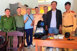 Cán bộ, chiến sỹ Phòng Cảnh sát Giao thông, Công an tỉnh Hà Giang và Công an xã Minh Tân (huyện Vị Xuyên) tiến hành trao trả lại tài sản cho ông Choi Kiyoung. (Ảnh: TTXVN phát) 
