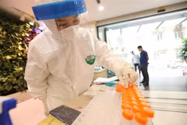Nhân viên xét nghiệm COVID-19. (Ảnh: Minh Quyết/TTXVN) 