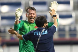 Thủ môn Tấn Trường chia vui cùng thành viên ban huấn luyện đội tuyển sau khi Quế Ngọc Hải nâng tỷ số lên 2-1 từ quả đá phạt đền ở phút 81. (Ảnh: Hoàng Linh/TTXVN) 