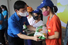 Anh Hoàng Văn Thanh, Phó Bí thư tỉnh đoàn Thanh Hóa trao gạo hỗ trợ cho các công nhân có hoàn cảnh khó khăn. (Ảnh: Nguyễn Nam/TTXVN) 