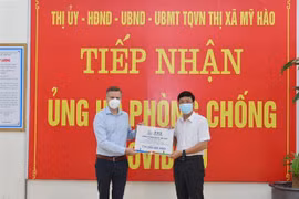 Ông Urs Kloeti, Giám đốc nhà máy Nestlé Bông Sen tại Hưng Yên, trao quà cho lãnh đạo thị xã Mỹ Hào để tiếp sức cho người dân bị ảnh hưởng bởi dịch COVID-19. (Ảnh: Đinh Tuấn/TTXVN) 