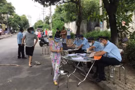 Lực lượng hải quan tỉnh Bình Dương chi viện hỗ trợ thành phố Dĩ An để kịp thời cấp phát tiền hỗ trợ cho dân trong vùng khóa chặt. (Ảnh: TTXVN phát) 