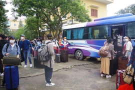 Các công dân lên xe về nhà sau khi hoàn thành thời gian cách ly tập trung. (Ảnh: Đinh Tuấn/TTXVN) 