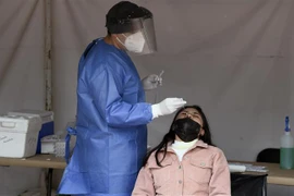 Nhân viên y tế lấy mẫu xét nghiệm COVID-19 cho người dân tại Mexico City. (Ảnh: AFP/TTXVN) 