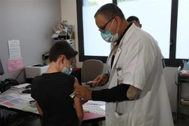 Nhân viên y tế tiêm vaccine phòng COVID-19 cho trẻ em tại Antibes, Pháp, ngày 23/12/2021. (Ảnh: THX/TTXVN) 