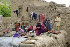 Các em nhỏ ngồi bên cạnh ngôi nhà bị phá hủy do mưa bão tại tỉnh Badghis , Afghanistan ngày 4/5/2022. (Ảnh: THX/TTXVN) 