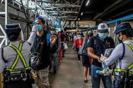 Kiểm tra thân nhiệt phòng lây nhiễm COVID-19 trước khi lên tàu tại Manila, Philippines. (Nguồn: THX/TTXVN) 