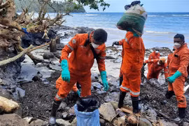 Lực lượng bảo vệ bờ biển và nhân viên tình nguyện dọn dầu loang Pola, tỉnh Oriental Mindoro, Philippines, ngày 8/3/2023. (Ảnh: AFP/TTXVN) 