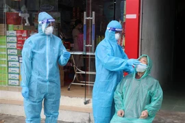 Nhân viên y tế lấy mẫu xét nghiệm virus SARS-CoV-2 trên địa bàn phường Vĩnh Bảo, thành phố Rạch Giá (Kiên Giang). (Ảnh: Lê Huy Hải/TTXVN) 