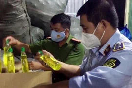 Tổ liên ngành chống buôn lậu tỉnh An Giang phát hiện hàng ngàn chai nước rửa chén nhái nhãn hiệu nổi tiếng tại cơ sở kinh doanh Lâm Thị Y. (Ảnh: TTXVN phát) 