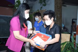 Chủ tịch Ủy ban Mặt trận Tổ quốc Việt Nam Thành phố Hà Nội Nguyễn Lan Hương trao quà cho người lao động gặp khó khăn trên địa bàn quận Tây Hồ. (Ảnh: Nguyễn Thắng/TTXVN)