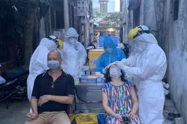 Lực lượng y tế lấy mẫu xét nghiệm những người liên quan đến các ca dương tính ở phường Việt Hưng (quận Long Biên, Hà Nội). (Ảnh: Văn Cảnh/TTXVN) 
