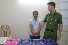 Đối tượng Tráng Láo Dua và tang vật tại cơ quan Công an. (Nguồn: TTXVN) 