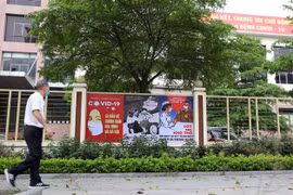 Tranh cổ động về phòng, chống COVID-19 được dán, treo ở các trụ sở cơ quan, trường học. (Ảnh: Thanh Tùng/TTXVN) 