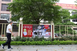 Tranh cổ động về phòng, chống COVID-19 được dán, treo ở các trụ sở cơ quan, trường học. (Ảnh: Thanh Tùng/TTXVN) 
