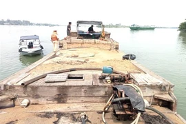 Chiếc ghe vận chuyển cát bị cơ quan công an tạm giữ. (Ảnh: TTXVN phát)